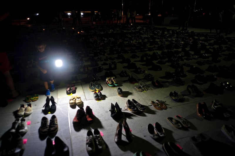 A child illuminates hundreds of shoes at a memorial for those killed by Hurricane Maria, in front of the Puerto Rico Capitol, in San Juan. Puerto Rico's Institute of Statistics announced that it has sued the US territory's health department and demographic registry seeking to obtain data on the number of deaths following Hurricane Maria as a growing number of critics accuse the government of lacking transparency. Ramon Espinosa / AP Photo