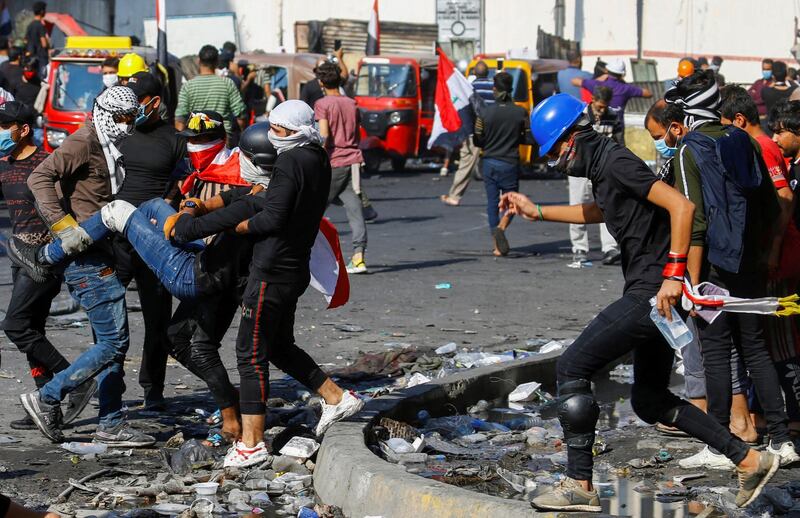 Iraqi demonstrators carry a wounded man during ongoing anti-government protests in Baghdad. Reuters