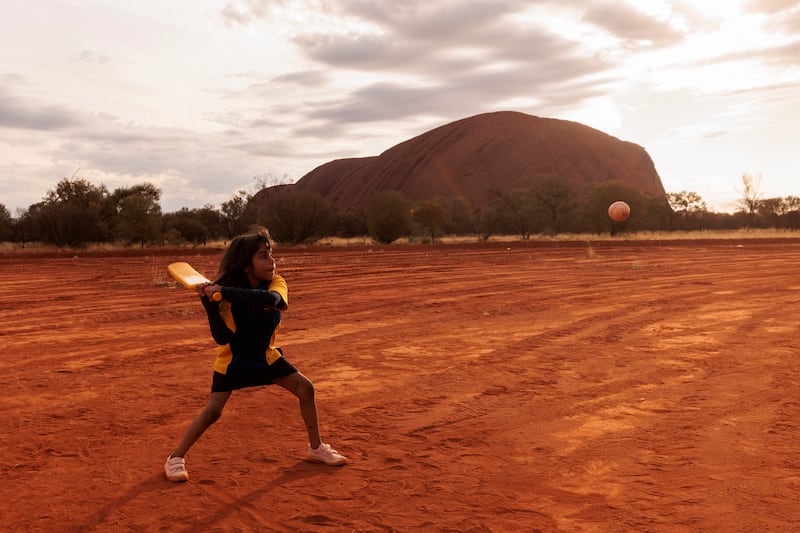 A child plays cricket during the ICC Men's T20 World Cup Trophy Tour at Mutitjulu in Uluru, Australia. Mutitjulu is an Aboriginal community located at the base of Uluru. Getty Images