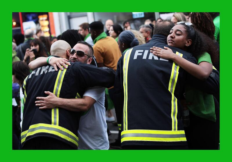 LONDON, ENGLAND - JUNE 14:  People stop to hug firefighters during a silent march to St Mark?s Park (Kensington Memorial Park) where an open Iftar will take place on the one year anniversary of the Grenfell Tower fire on June 14, 2018 in London, England. In one of Britain's worst urban tragedies since World War II, a devastating fire broke out in the 24-storey Grenfell Tower on June 14, 2017 where 72 people died from the blaze in the public housing building of North Kensington area of London.  (Photo by Dan Kitwood/Getty Images)***BESTPIX***