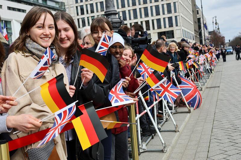 People wave German and British flags as they wait for the arrival of King Charles in Berlin during his visit to Germany. Getty