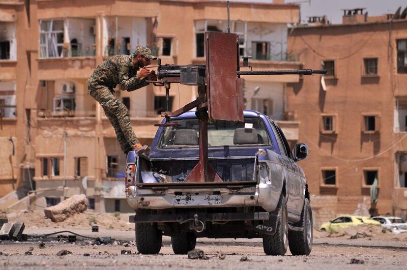 A member of the Kurdish People's Protection Units (YPG) mans a mounted machine gun in the Al Nashwa neighbourhood in the northeastern Syrian province of Hasakeh on July 26, 2015. Delil Souleiman / AFP Photo

