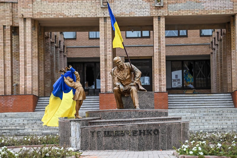 Ukrainian flags are placed on statues in a square in Balakliia. AFP