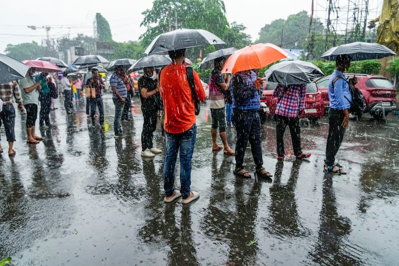 Stranded passengers await transport in Kolkata. Millions of people in the city have been left without electricity amid heavy rain. AP