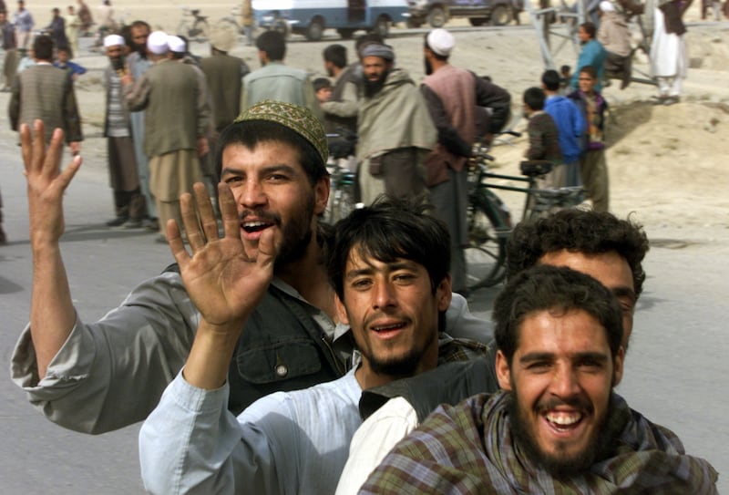 Kabul residents riding a bicycle celebrate as Northern Alliance
fighters enter the Afghan capital in November 2001 after the collapse of Taliban rule.