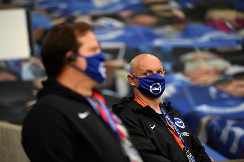 Ground staff wearing face masks to prevent the spread of the coronavirus stand on the pitch ahead of the English Premier League soccer match between Brighton & Hove Albion and Manchester United at the AMEX Stadium in Brighton, England. AP Photo