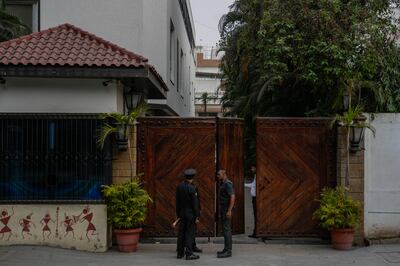 Security guards stand at the entrance of Bollywood superstar Amitabh Bachchan's house in Mumbai. AP