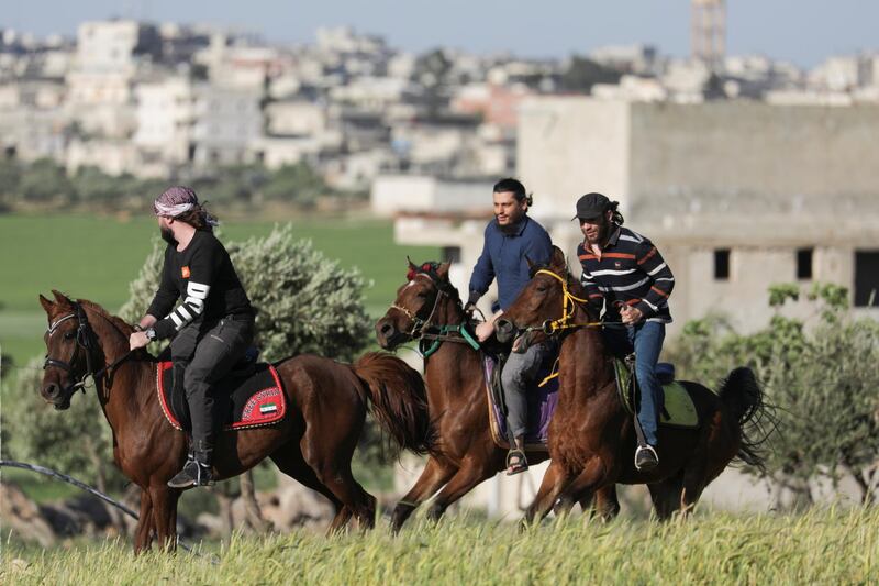 Men ride horses at a horse club in Idlib, Syria April 22, 2021. Picture taken April 22, 2021. REUTERS/Mahmoud Hassano