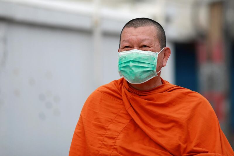 A Buddhist monk wears a mask to prevent the spread of the new coronavirus as he collects alms in Chinatown at Bangkok, Thailand. Reuters