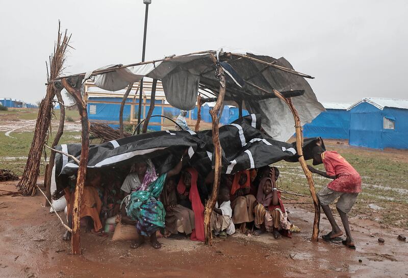 Sudanese refugees sit inside a makeshift shelter during a rainstorm at a refugee camp in Ourang on the outskirts of Adre, Chad.