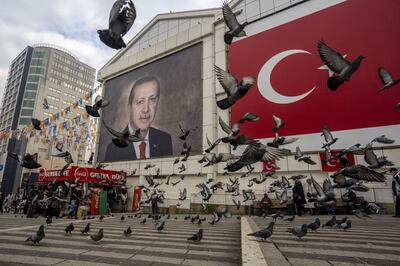 Pigeons take flight in front of a mural of Turkish President Recep Erdogan in Bursa, Turkey, on Tuesday, Jan.  4, 2022.  Turkish investors are still clinging to foreign currencies, undermining President Recep Tayyip Erdogan's plan to support the lira without raising interest rates. Photographer: Moe Zoyari / Bloomberg