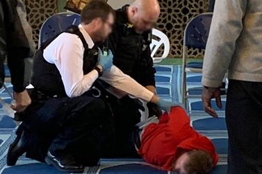 An image of a man being held down by police officers at a London mosque. Murshid Habib / Twitter