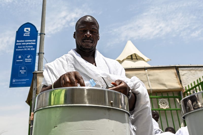 Pilgrim refills water bottle in Mina amid high summer temperatures during Hajj. AFP