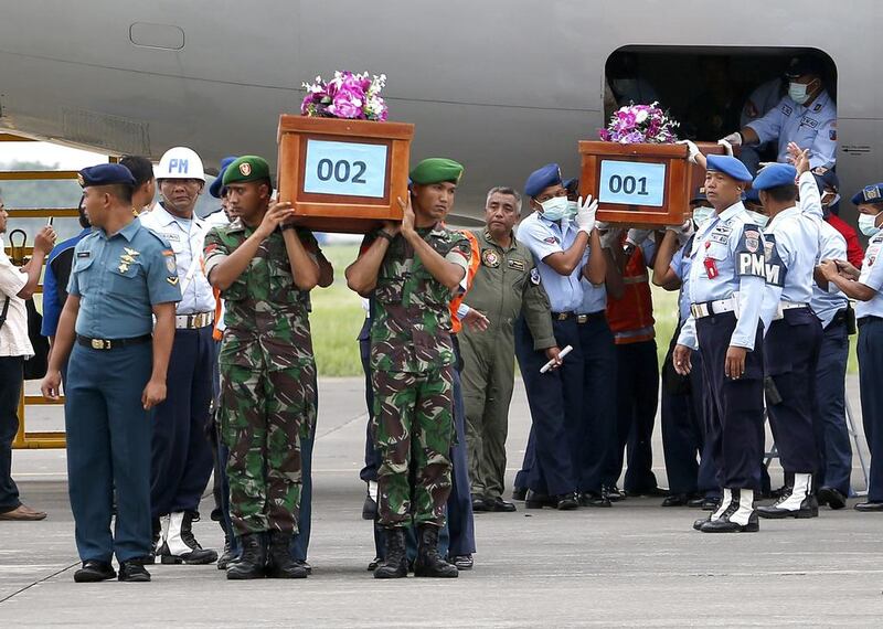Indonesian military personnel carry two coffins as the first bodies recovered from the crash site of AirAsia's doomed flight QZ8501 arrive at Juanda Airport, in Surabaya, Indonesia on 31 December 2014. The airliner carrying 162 people crashed into the Java Sea on 28 December, about halfway through a two-hour flight between Surabaya and Singapore. Made Nagi/ EPA
