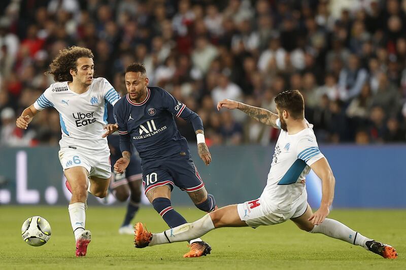 Paris Saint Germain's Neymar dribbles past Marseille's Duje Caleta-Car, right, and Matteo Guendouzi. EPA 