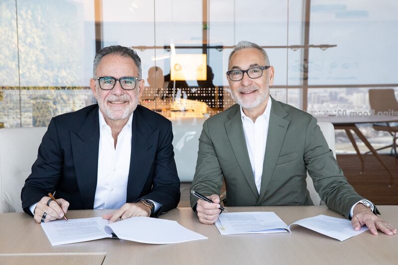Halim Shehadeh, chief executive and founder of CWB Group, left, and Slobodan Petošević, founder of Petošević, sign merger documents. Photo: Gulf Capital