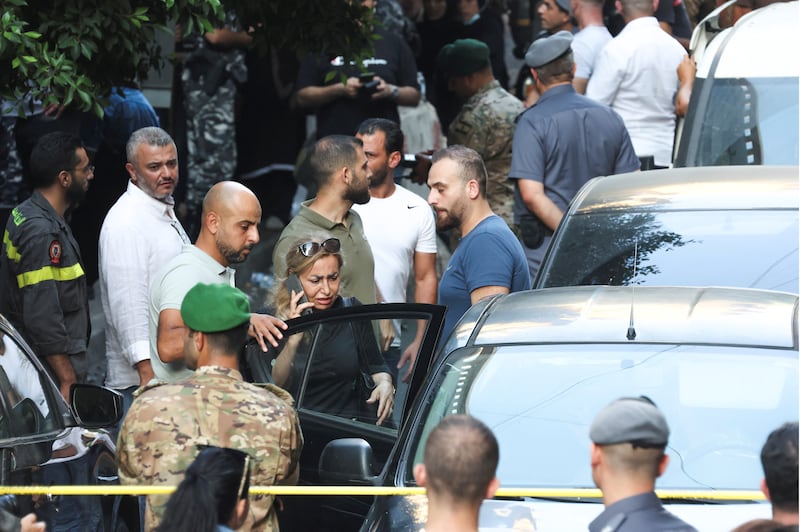 A woman who was held hostage inside the Federal bank of Lebanon enters a car after her release. Reuters