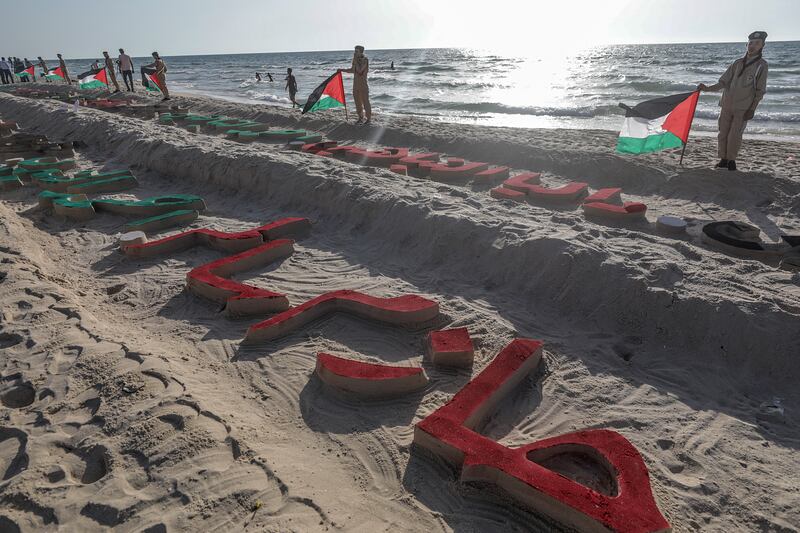 Palestinian children carrying national flags, as well as other Palestinians, gathered during the commemorative event. EPA