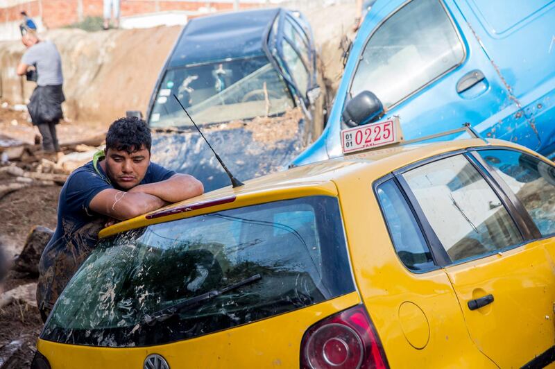 A man stands with his car after torrential rains in Mohamedia, Tunisia. Hassene Dridi / AP Photo