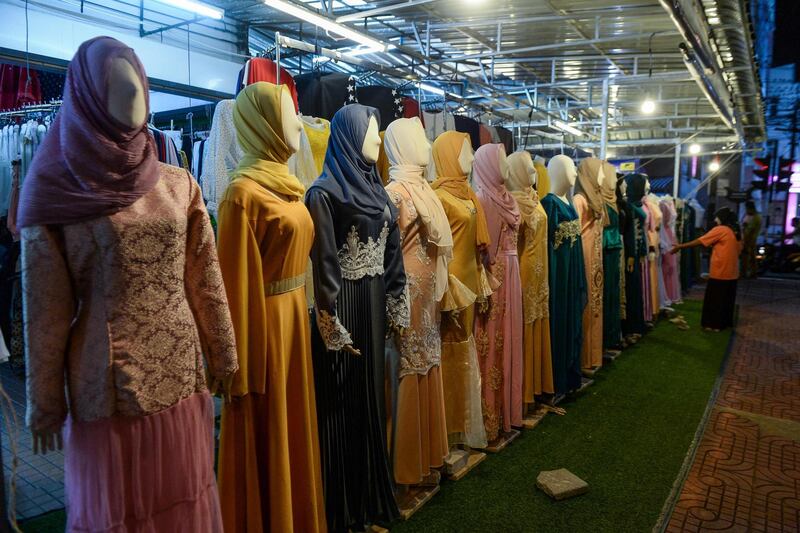 A Muslim woman looking at clothing while shopping for Eid Al Fitr in a market in Narathiwat. AFP