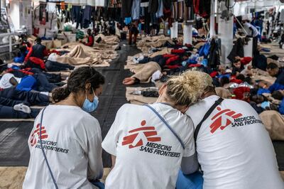 A handout picture by Doctors Without Borders (MSF) shows MSF members resting on the Geo Barents crew after rescuing migrants at approximatively 30 miles from the Libyan shores. 