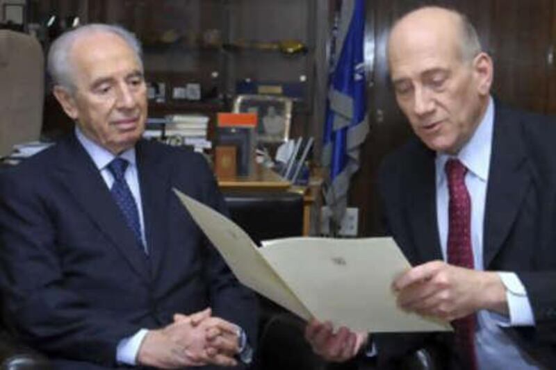 In this photo released by Israel's Government Press Office, Israeli Prime Minister Ehud Olmert, right, reads his resignation letter to the Israeli president Shimon Peres as he hands in his resignation at the President's residence in Jerusalem on Sept 21 2008.
