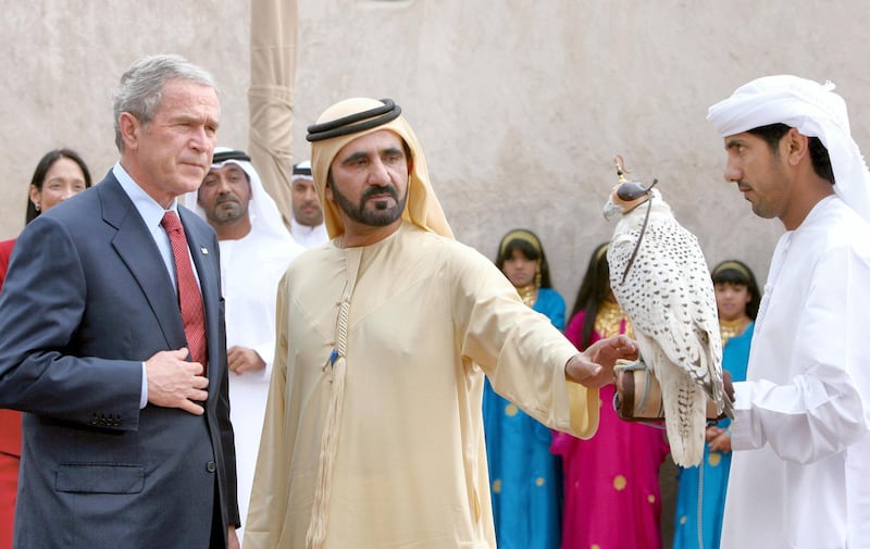 In this handout picture released by the official Emriati news agency WAM, Emirati Vice President, Prime Minister, Defence Minister and ruler of the emirate of Dubai, Sheikh Mohammed bin Rashid al-Maktoum  (C), shows a falcon to US President George W. Bush (L) 14 January 2008 during a visit to the Sheikh Saeed al-Maktoum House in Dubai. Bush called on Washington's oil-rich Gulf Arab allies to support US policy goals in the Middle East.  AFP PHOTO/HO/WAM (Photo by WAM / AFP)