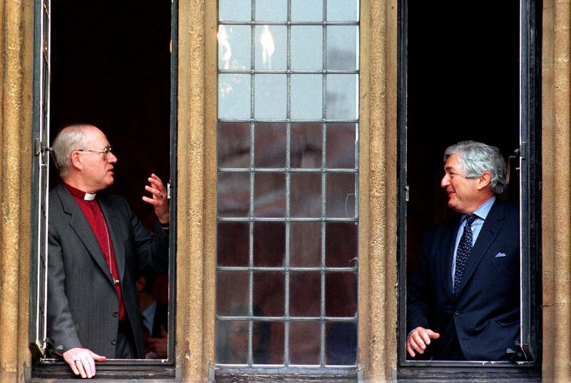 Wolfensohn and the former archbishop of Canterbury George Carey chat at an open window during a break in the World Faiths Development Dialogue in February 1998. Reuters