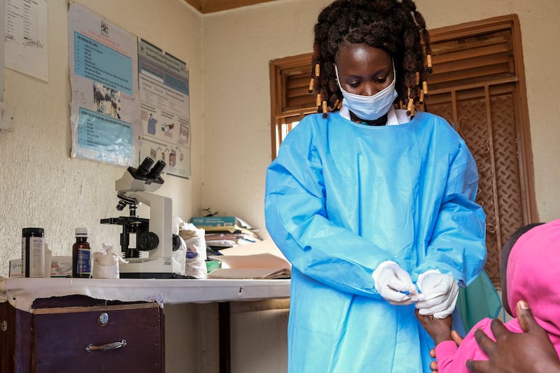 Medical laboratory assistant Mellon Kyomugisha, who said she was the first to examine the first confirmed Ebola victim when he came to St Florence Clinic with malaria, takes a blood sample from a toddler at the clinic in Madudu, Uganda, on Wednesday, September 28.  In this remote Ugandan community facing its first Ebola outbreak, testing trouble has added to the challenges with symptoms of the Sudan strain of Ebola being similar to malaria, underscoring the pitfalls health workers face in their response. AP