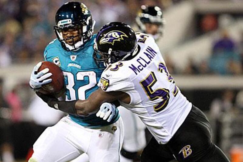 Maurice Jones-Drew, left, is tackled to the ground by the Baltimore linebacker Jameel McClain. The Jacksonville running back went 105 yards on 30 carries.