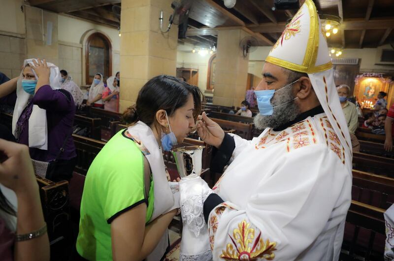 Priest Abdel Masseh Baset of the Historical  Church of Blessed Virgin Mary gives Sacramental bread to coptic at Mostorod district in Cairo, Egypt.  EPA