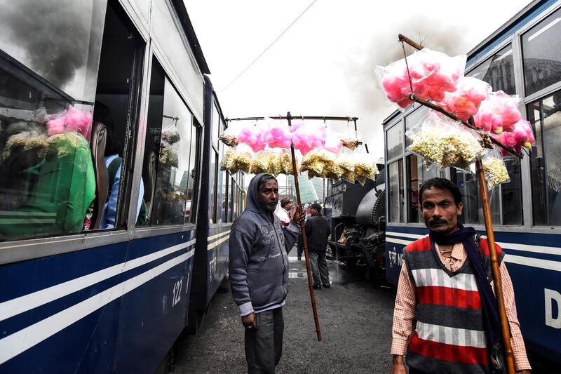 Vendors sell candy floss to passengers as Darjeeling Himalayan Railway trains arrive at a station in Ghum.