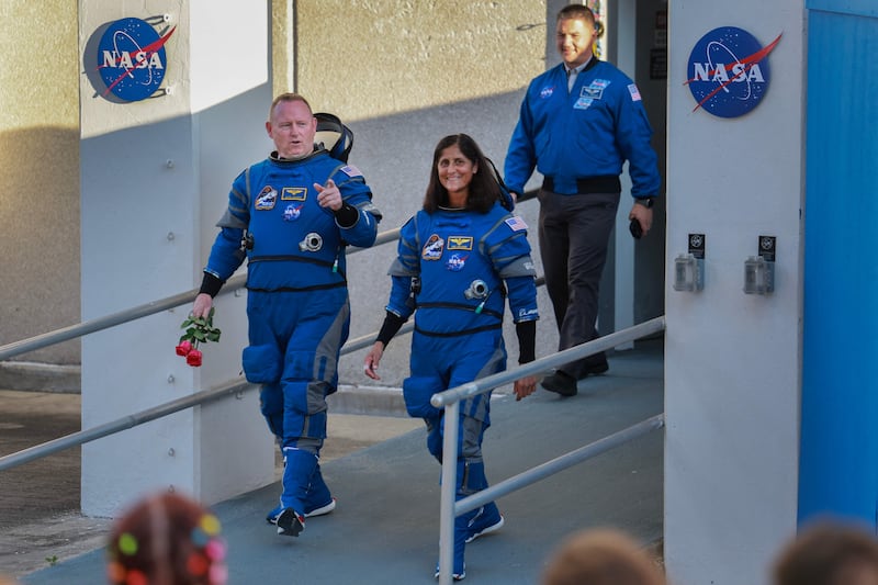 The crew walks out of a Nasa building to head to the launch pad. The flight was postponed because of a valve problem on the rocket. Getty Images / AFP
