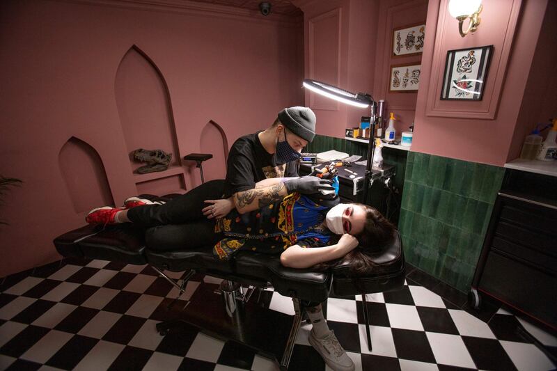 A tattooist works on a customer at the Heartbreak Social Club tatoo parlour in Dublin on December 1. AFP