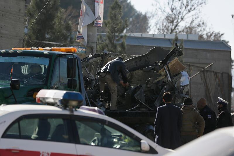 Afghan security personnel prepare to carry a damaged car which was used for a car bomb explosion in Kabul, Afghanistan, Thursday, Dec. 31, 2020. (AP Photo/Mariam Zuhaib)