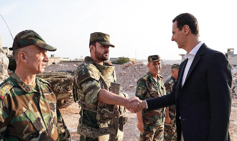 Assad shakes hands with regime troops in Idlib. EPA