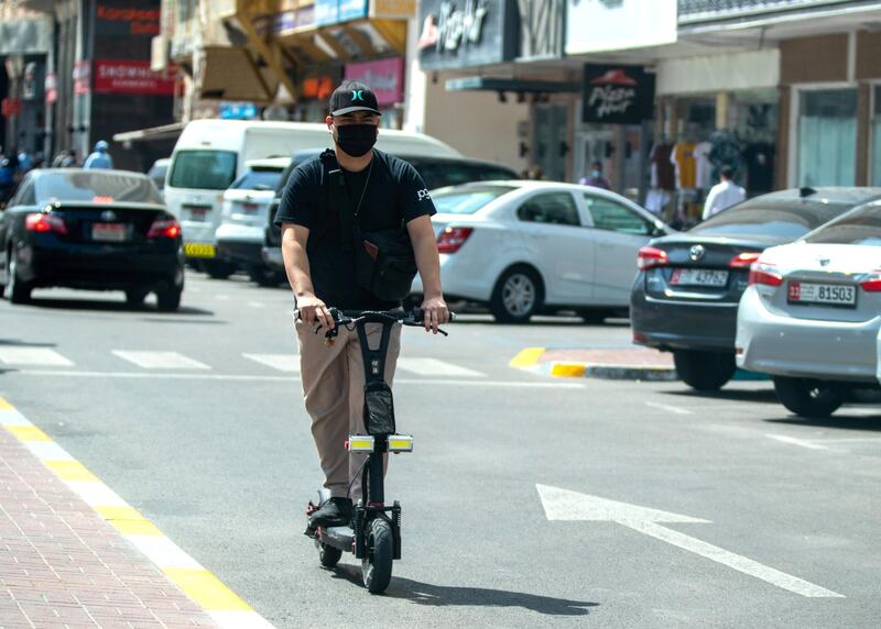 Abu Dhabi, United Arab Emirates, March 1, 2021.  An e-scooter rider counterflows oncoming traffic on Hamdan Steet, central Abu Dhabi.Victor Besa / The NationalSection:  NA
