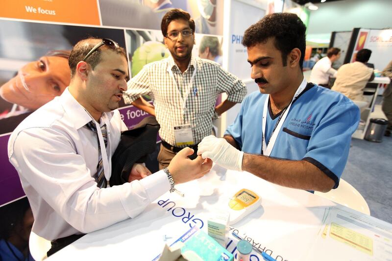 October 17, 2010 / Abu Dhabi / (Rich-Joseph Facun / The National) Mohamad Halas (CQ), left, has his cholesterol level checked by Riyas Kizhakkayil Meethel (CQ), right, a Registered Nurse with Lifeline Hospital, free of charge at the Abu Dhabi Medical Congress exhibition, Sunday, October 17, 2010 in Abu Dhabi. 