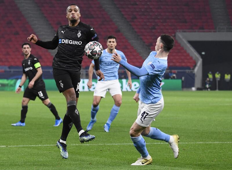 Moenchengladbach's French forward Alassane Plea (L) and Manchester City's English midfielder Phil Foden vie for the ball during the UEFA Champions League, last 16, 1st-leg football match Borussia Moenchengladbach v Manchester City at the Puskas Arena in Budapest on February 24, 2021. (Photo by Attila KISBENEDEK / AFP)