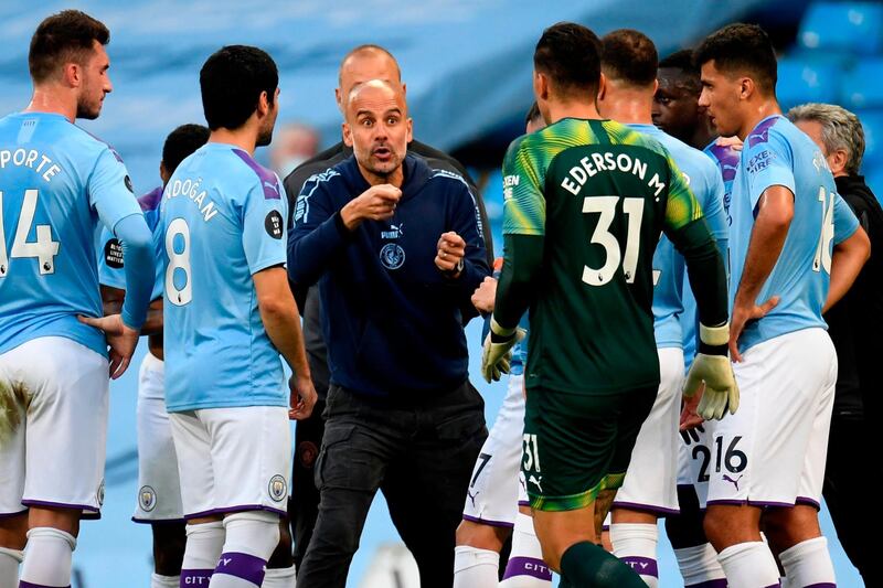 (FILES) In this file photo taken on July 02, 2020 Manchester City's Spanish manager Pep Guardiola (C) speaks with his players during the drinks break during the English Premier League football match between Manchester City and Liverpool at the Etihad Stadium in Manchester, north west England, on July 2, 2020. Liverpool and Manchester City remain the sides to beat after three seasons of unprecedented dominance but a rejuvenated Manchester United and free-spending Chelsea could force themselves into a four-way race for the title. / AFP / POOL / PETER POWELL / TO GO WITH AFP STORY BY Kieran CANNING
