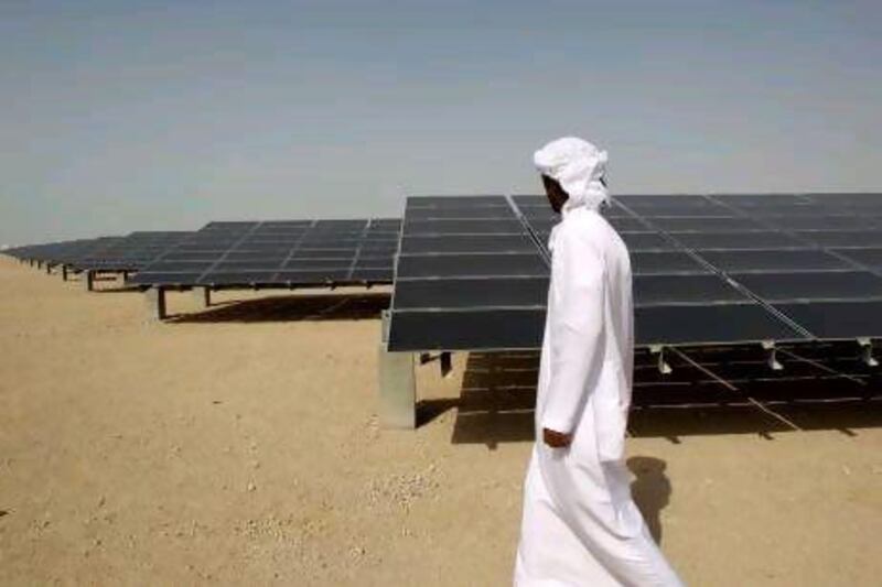 An Emirati man pass by 10mw photovoltaic plant at Masdar City in Abu Dhabi. AP Photo/Kamran Jebreili