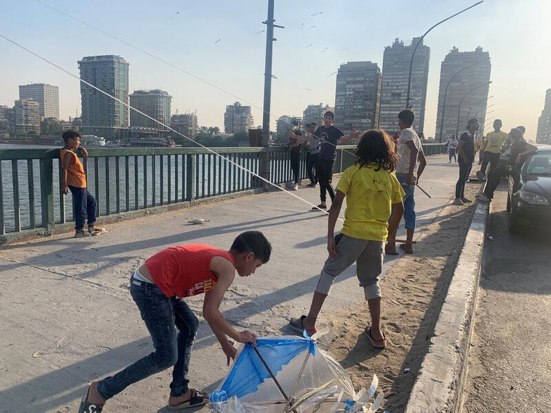 Egyptian boys flying kites off a Nile bridge in Cairo. Hamza Hendawi for The National