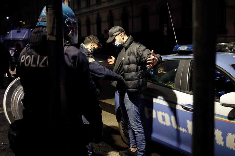 Police detain a man following a protest in Milan. AP Photo