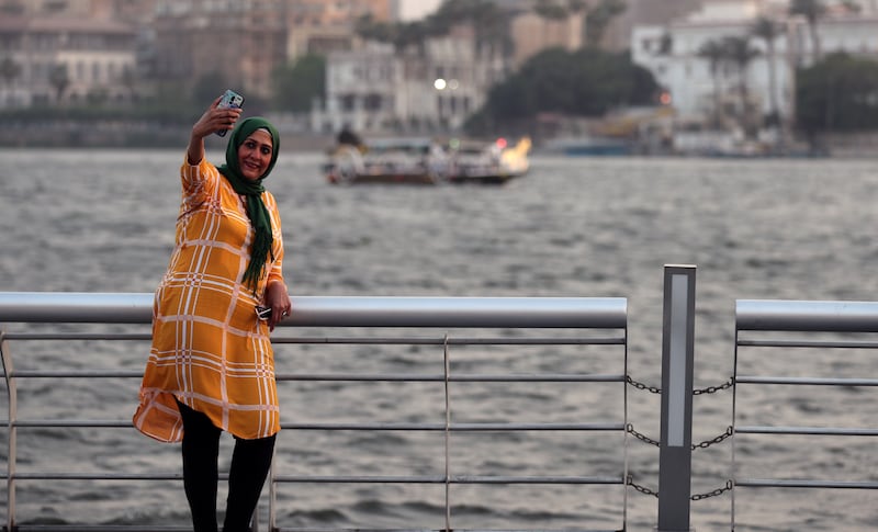 A woman takes a selfie at Egypt's first modern walkway overlooking the Nile in Cairo, Egypt. The country will allow photographs in public places without permits, under certain conditions. EPA