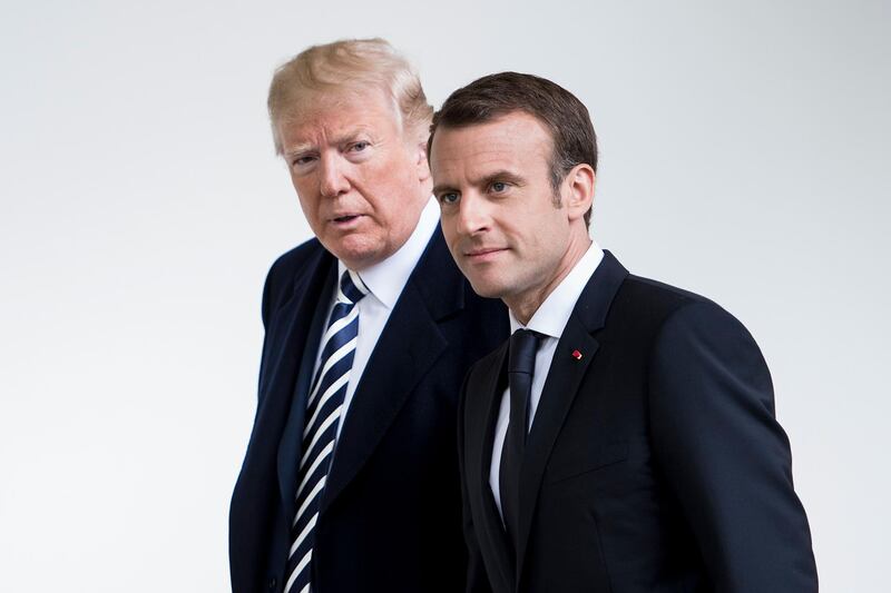 US President Donald Trump (L) and French President Emmanuel Macron walk through the Colonnade before heading to the Oval Office at the White House in Washington, DC, on April 24, 2018. / AFP PHOTO / Brendan Smialowski