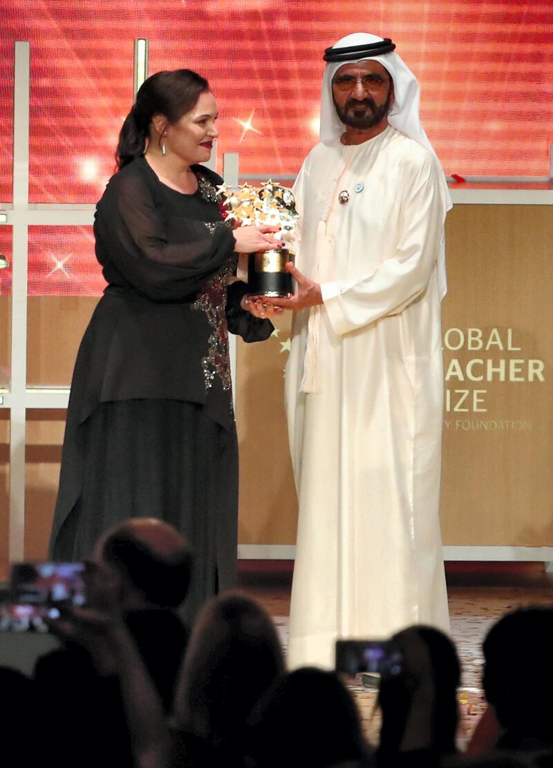 British teacher Andria Zafirakou receives the "Global Teacher Prize" from Sheikh Mohammed bin Rashid al-Maktoum, Vice-President and Prime Minister of the UAE and Ruler of Dubai during an award ceremony in Dubai on March 18, 2018. - Zafirakou who  was among ten finalists chosen from 179 countries, won one million dollars of prize money. (Photo by KARIM SAHIB / AFP)