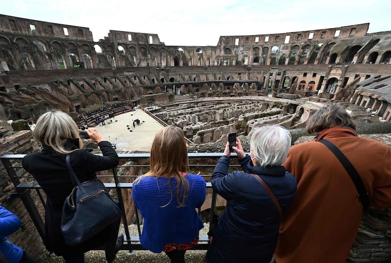 Visitors take pictures as singers and musicians perform at Rome's landmark Colosseum as it reopens amid an easing of coronavirus restrictions. AFP