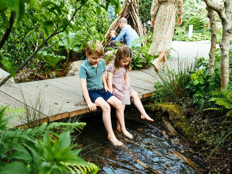 In this image made available on Sunday May 19, 2019 by Kensington Palace, Britain's Prince William, Kate, Duchess of Cambridge and their children, Prince George, front, Princess Charlotte, front, and Prince Louis play in the Adam White and Andree Davies co-designed garden ahead of the RHS Chelsea Flower Show in London. (Matt Porteous/Kensington Palace via AP)