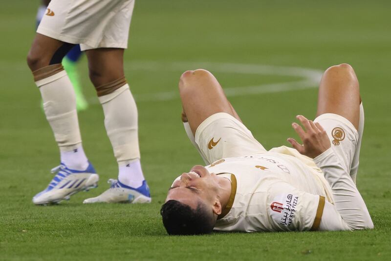 Al Nassr's Cristiano Ronaldo lays on the field injured. AFP