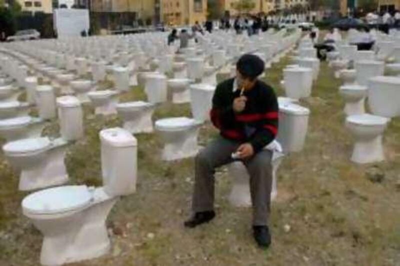 BEIRUT, LEBANON, Sunday April 13, 2008: A man smokes as he sits on a toilet seat during a public installation titled :"Haven't 15 years of hiding in the toilets been enough!?," by artist Nada Sehnaoui, referring to the 15 years of civil war in Beirut. Lebanese marked Sunday the 33rd anniversary of the beginning of the country's civil war. Courtesy of AP Photo/Ahmad Omar